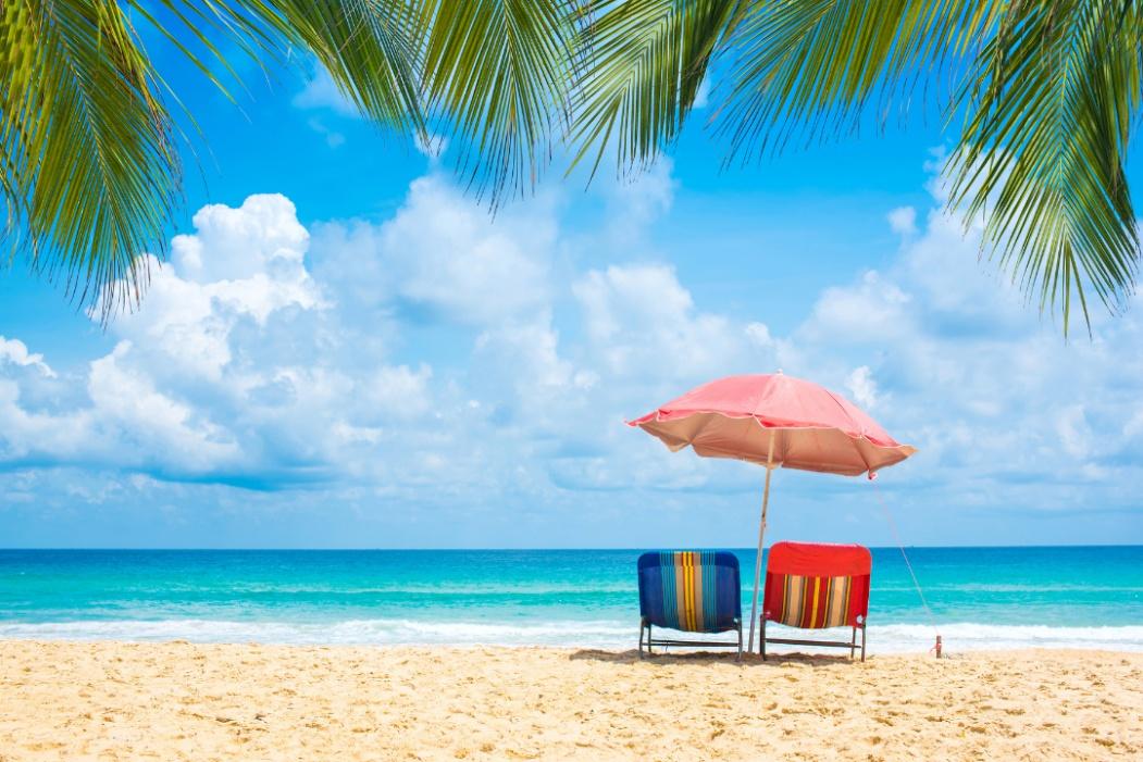 Two chairs underneath an umbrella on the beach